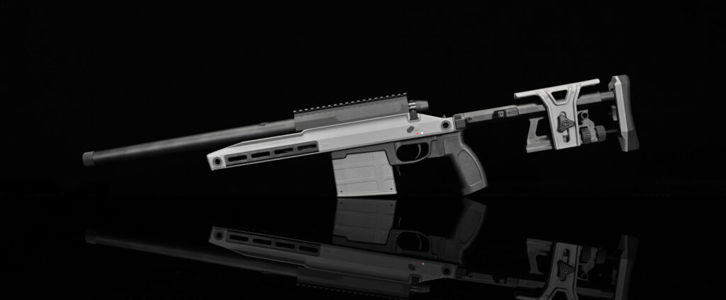 This image features another perspective of the tactical firearm, showcasing details such as the muzzle, handguard with ventilation holes, and the firearm's body with the Picatinny rail. The adjustable stock and ergonomic grip are also visible. The reflection below the firearm adds depth to the composition, emphasizing the firearm's design against the dark backdrop.