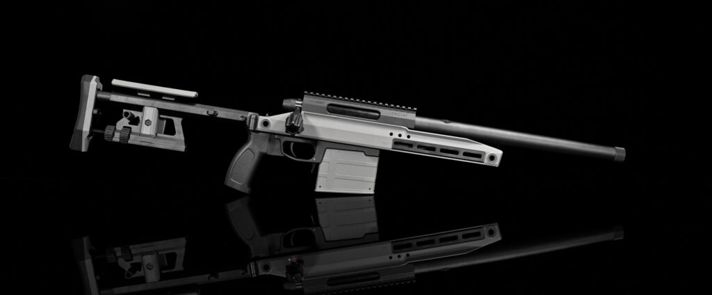 This image displays a modern tactical firearm with features like an adjustable buttstock, ergonomic grip, Picatinny rail system, and a precision barrel labeled with "TAC-41". The firearm is set against a dark reflective backdrop, highlighting its detailed craftsmanship.